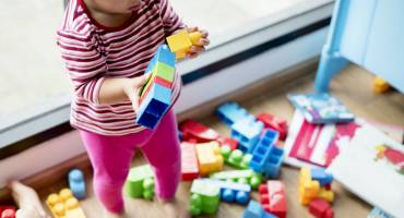 Petite fille qui joue avec des briques empilables